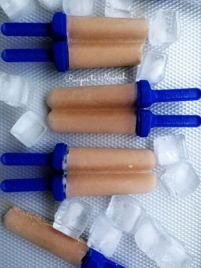 Homemade chocolate popsicles on a tray with ice.
