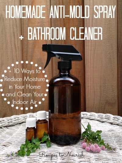 Glass spray bottle with natural cleaner, essential oils and fresh herbs.