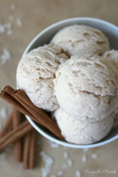 Several scoops of ice cream in a large bowl with cinnamon sticks.