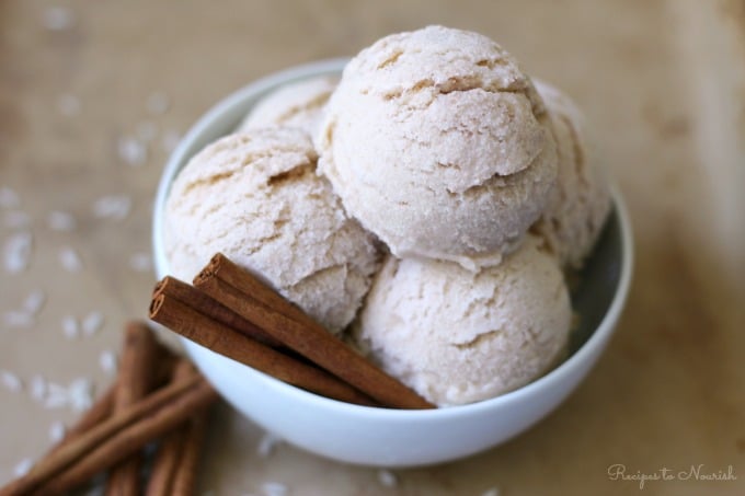 Large bowl with several scoops of ice cream with cinnamon sticks and white rice around it.