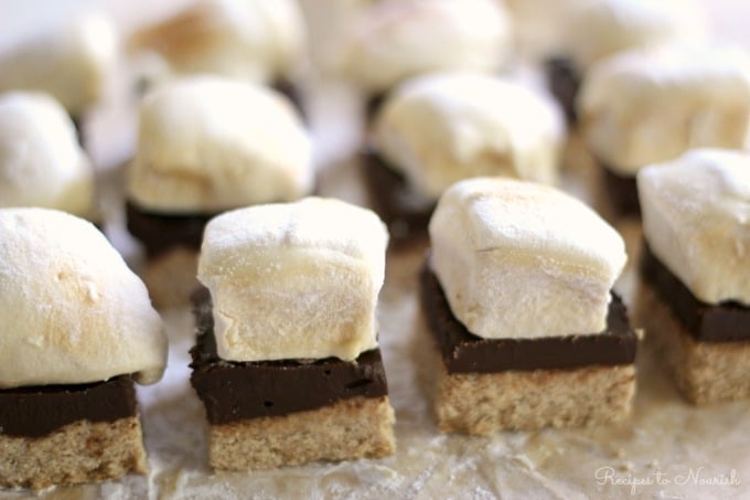 S'mores bars with homemade marshmallows on top of a layer of chocolate and cookie crust.