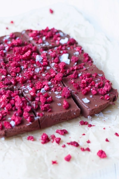 Chocolate Freezer Fudge is so easy to make! This creamy, delicious, chocolatey perfection is topped with sweet, crunchy freeze-dried raspberries and flaked sea salt. It has a special nourishing protein boost too! | Recipes to Nourish