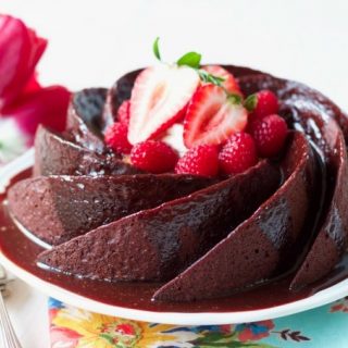 Chocolate cake with chocolate glaze topped with berries.