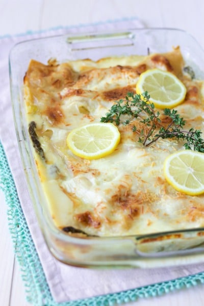 Creamy white sauce lasagna with cheesy top, fresh lemon slices and fresh thyme.