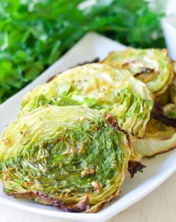 Roasted cabbage steaks with green sauce.