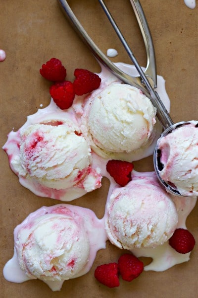 Scoops of raspberry swirl frozen yogurt with fresh raspberries. 