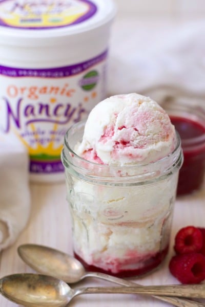 Scoops of raspberry swirl frozen yogurt with raspberry sauce, fresh raspberries and Nancy's organic yogurt.