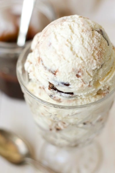 Ice cream in a glass with chocolate fudge sauce in the background. 