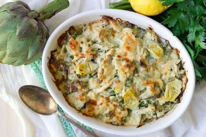 Healthy Spinach Artichoke Chicken Casserole with fresh lemon, artichoke and parsley.