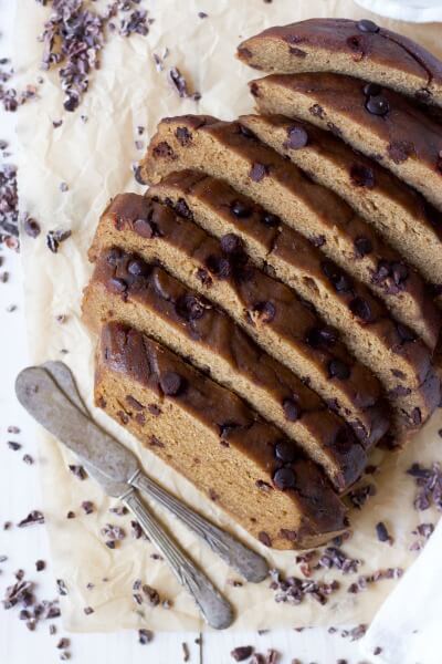 Slices of chocolate chip banana bread with two butter knives. 