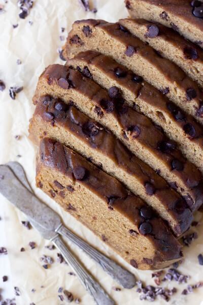 Slices of chocolate chip banana bread with two butter knives. 