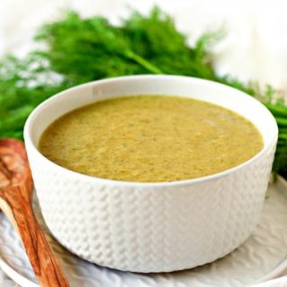 Broccoli soup in a bowl with fresh dill.