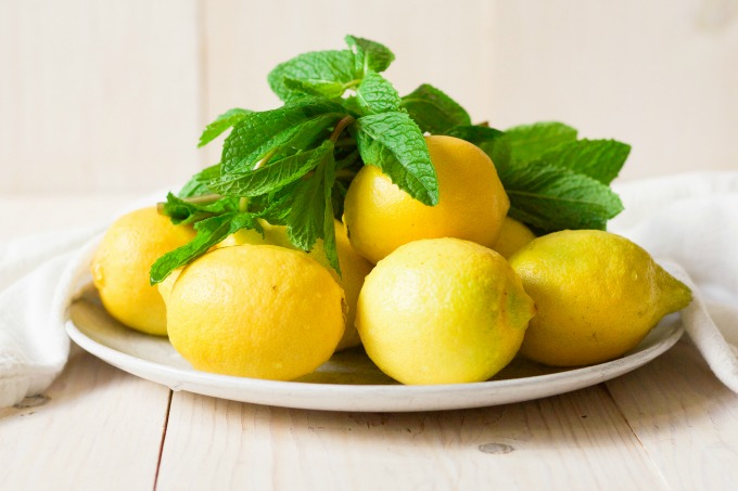 Organic lemons and fresh mint on a plate.