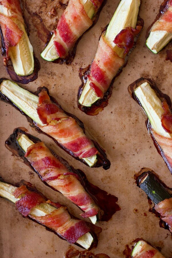 Bacon wrapped zucchini on a baking pan.