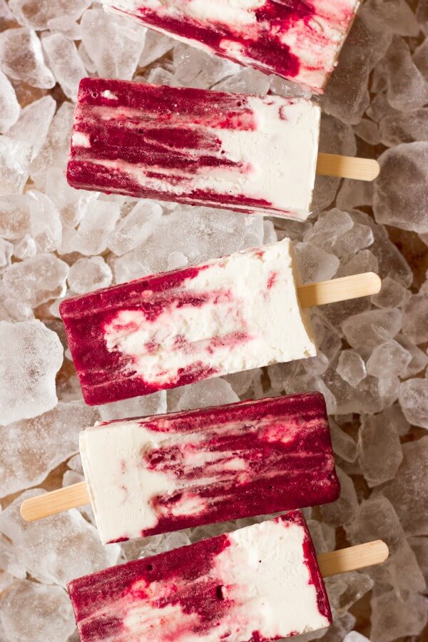 Marbles cherry and vanilla creamsicle popsicles on ice.