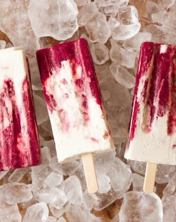 Marbled cherry and vanilla creamsicles on ice.