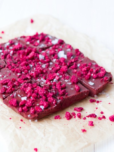 Large square of chocolate fudge cut into smaller squares and topped with freeze dried raspberries.
