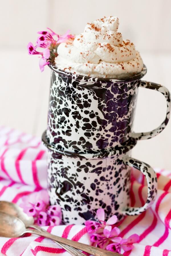 Mugs full of whipped cream topped with shaved chocolate.