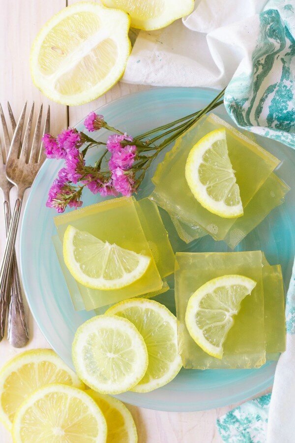 Square slices of homemade lemon jello with lemon slices.