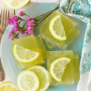 Square slices of homemade lemon jello with lemon slices.