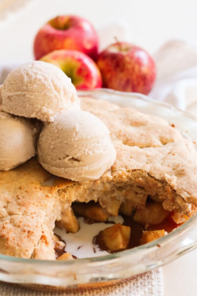 Apple cobbler topped with scoops of ice cream.