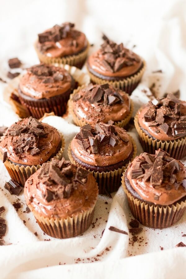 Chocolate cupcakes with chocolate frosting and chocolate chunks on the top.
