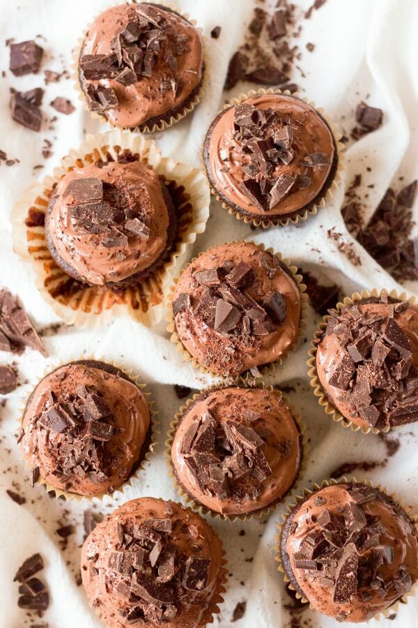 Chocolate cupcakes with chocolate frosting and chocolate chunks on the top.