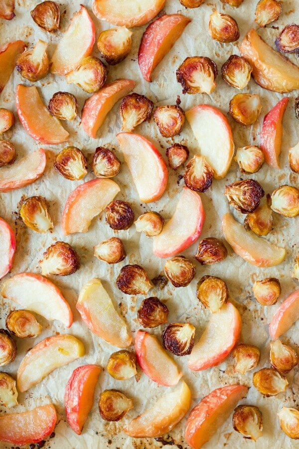 Roasted Brussels sprouts and apples on a baking sheet.