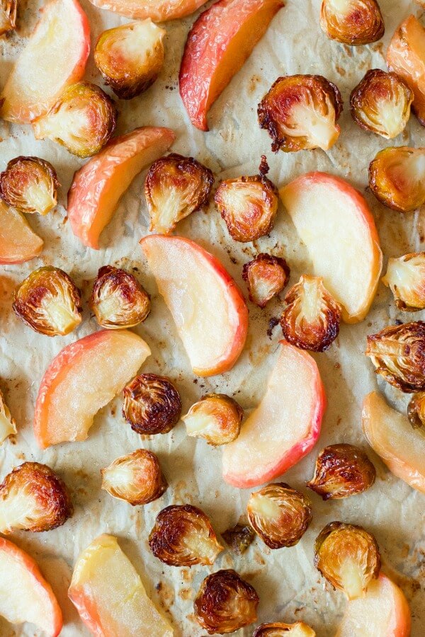 Roasted Brussels sprouts and apples on a baking sheet.