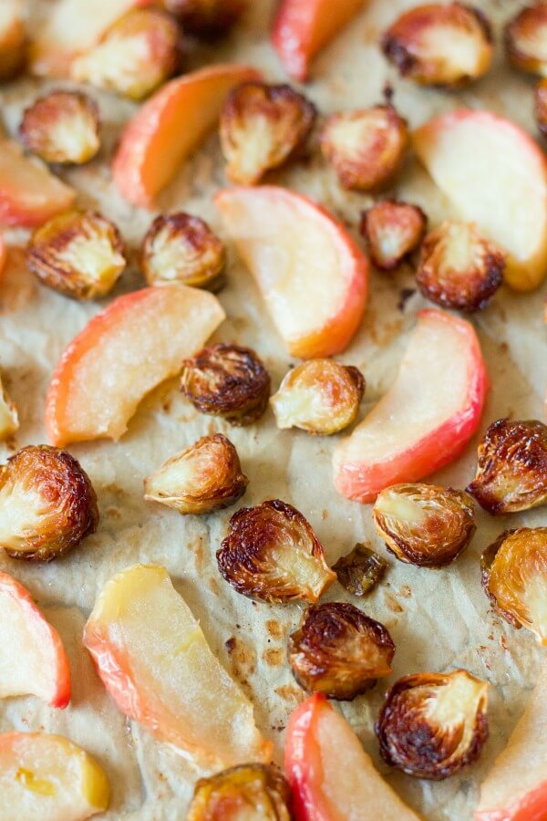 Roasted Brussels sprouts and apples on a baking sheet.