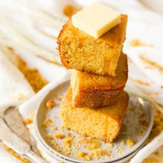 Stack of cornbread slices with butter and honey drizzle.