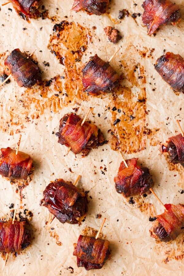 Bacon wrapped dates on baking sheet.