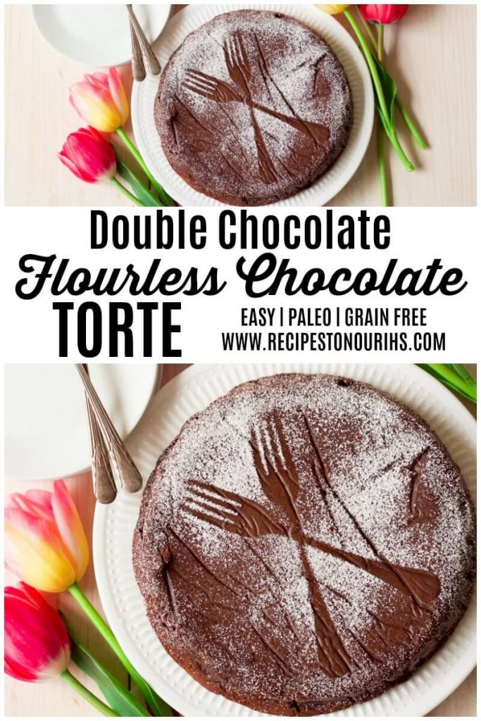 Chocolate torte cake dusted with powdered sugar making two forks pattern next to tulips.