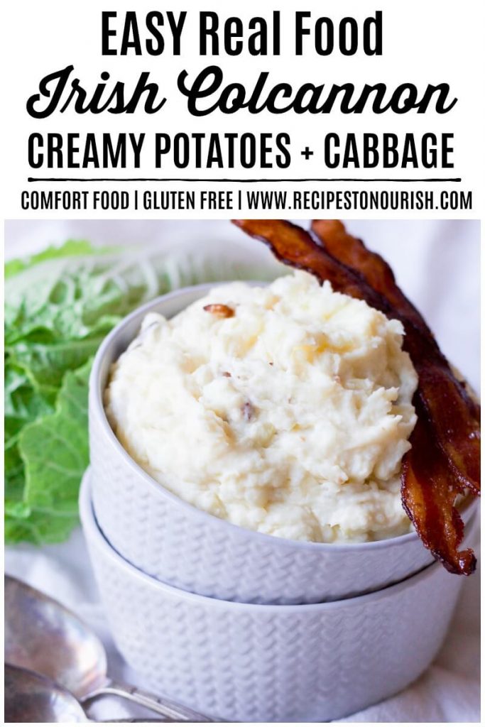 Mashed potatoes in a bowl with bacon and cabbage on the side.