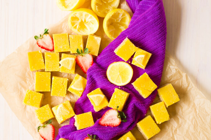 Homemade lemon squares with fresh lemon and strawberries.