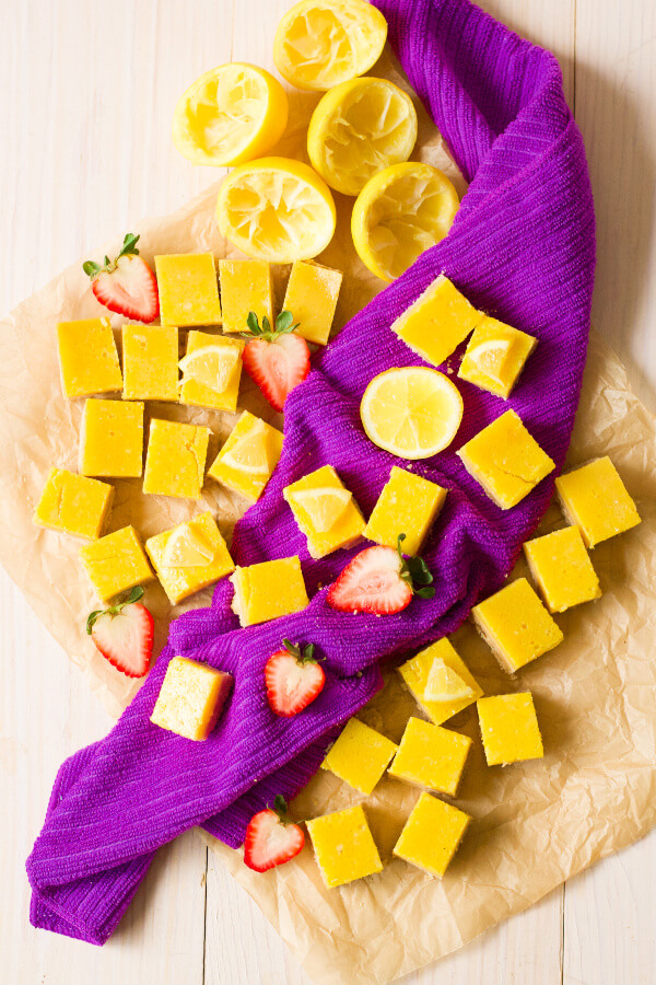 Homemade lemon squares with fresh lemon and strawberries.