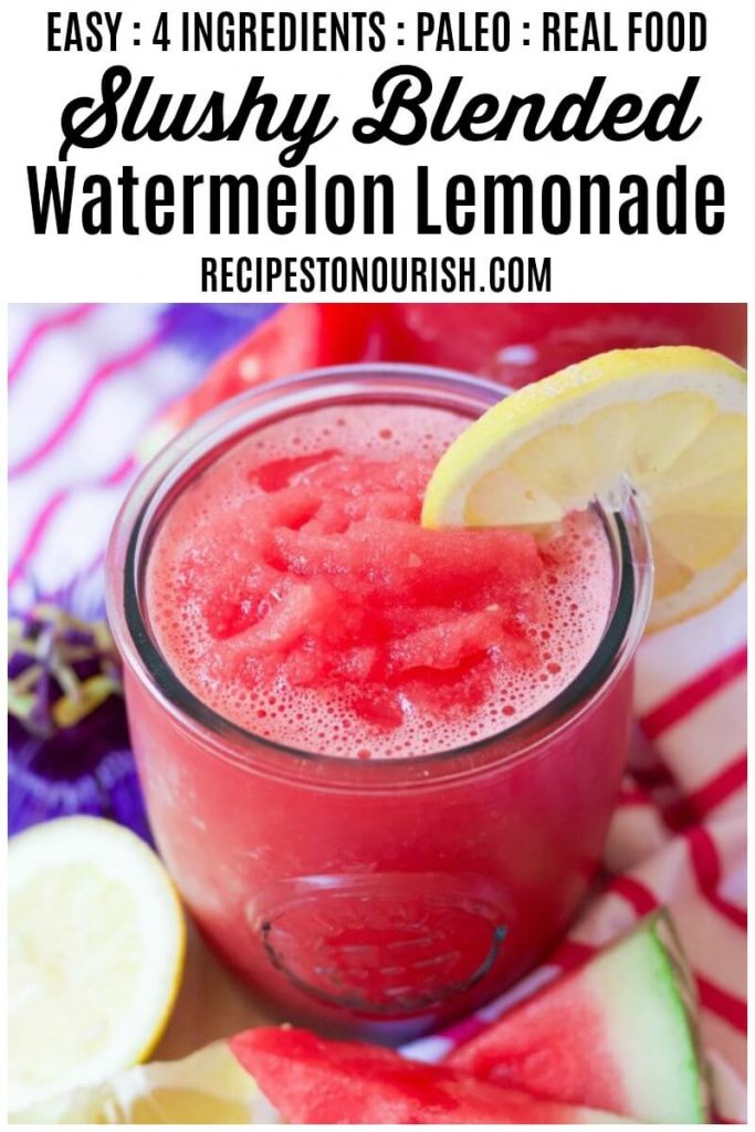 Glass full of pink slushy watermelon lemonade with fresh lemon slices and watermelon slices.