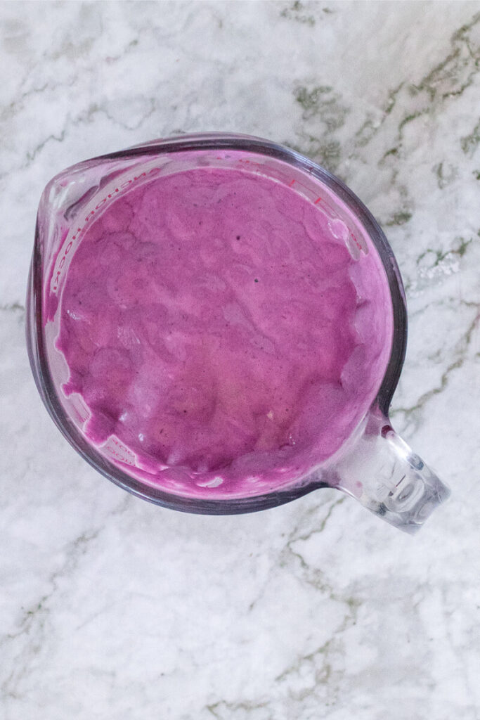 Creamy purple mixture in a large glass measuring cup.