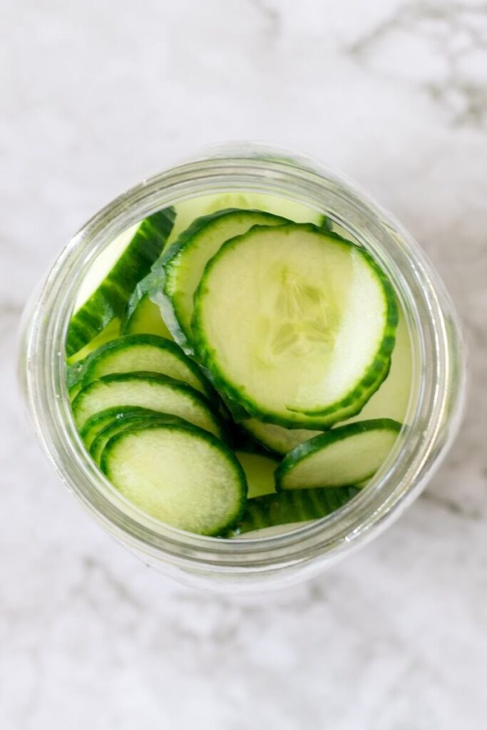 Overhead shot of a mason jar filled with sliced cucumbers.