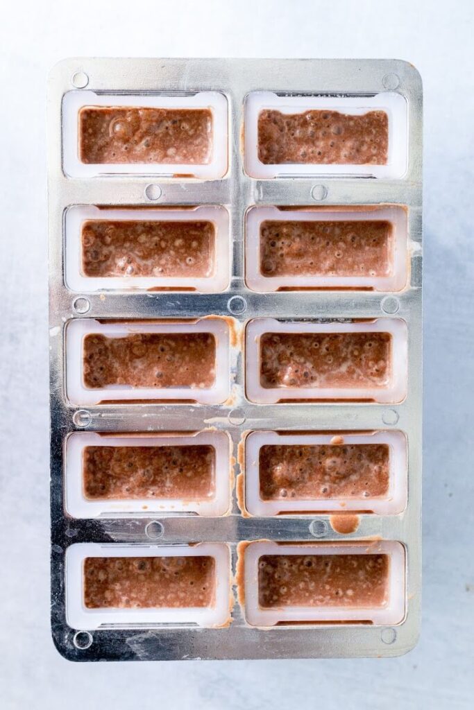 10 popsicle molds filled with chocolate mixture.