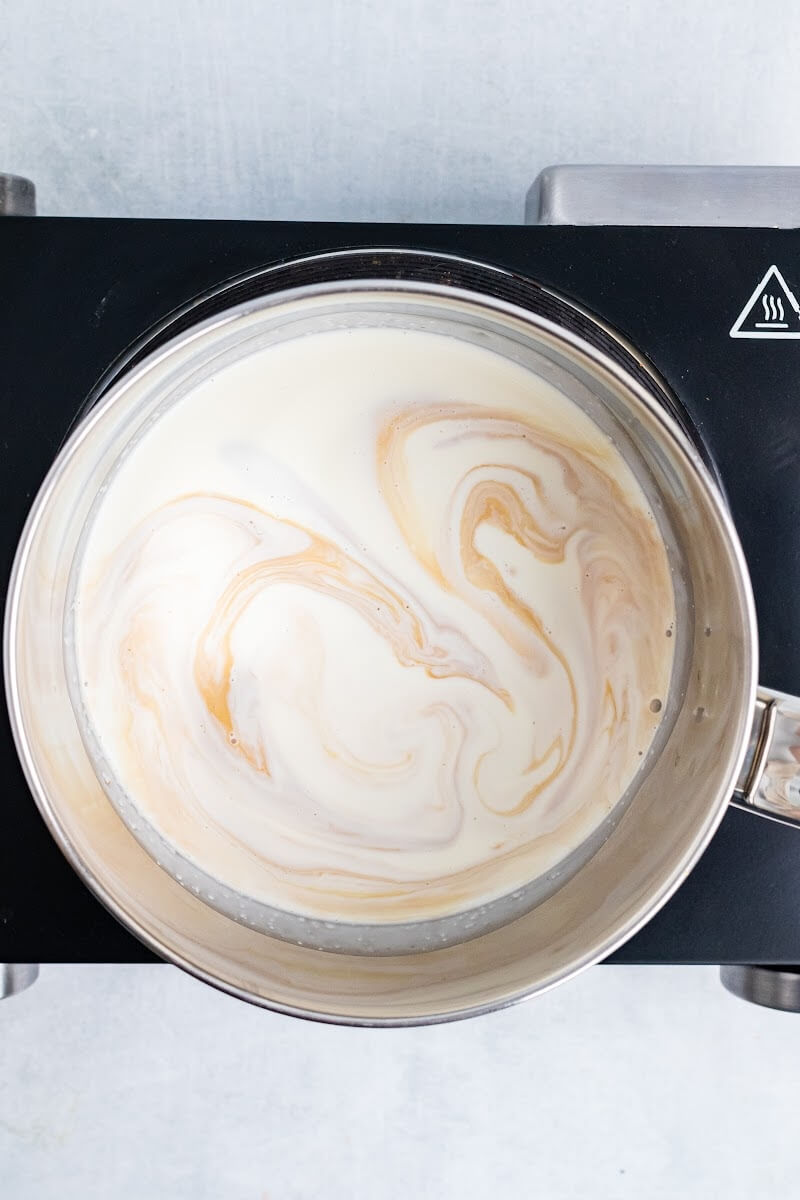 Saucepan with cream and vanilla extract.