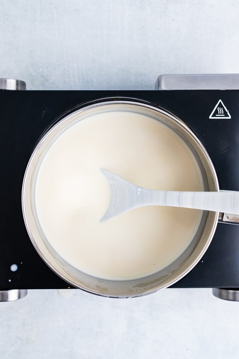 Saucepan with stirring spoon in a cream mixture.