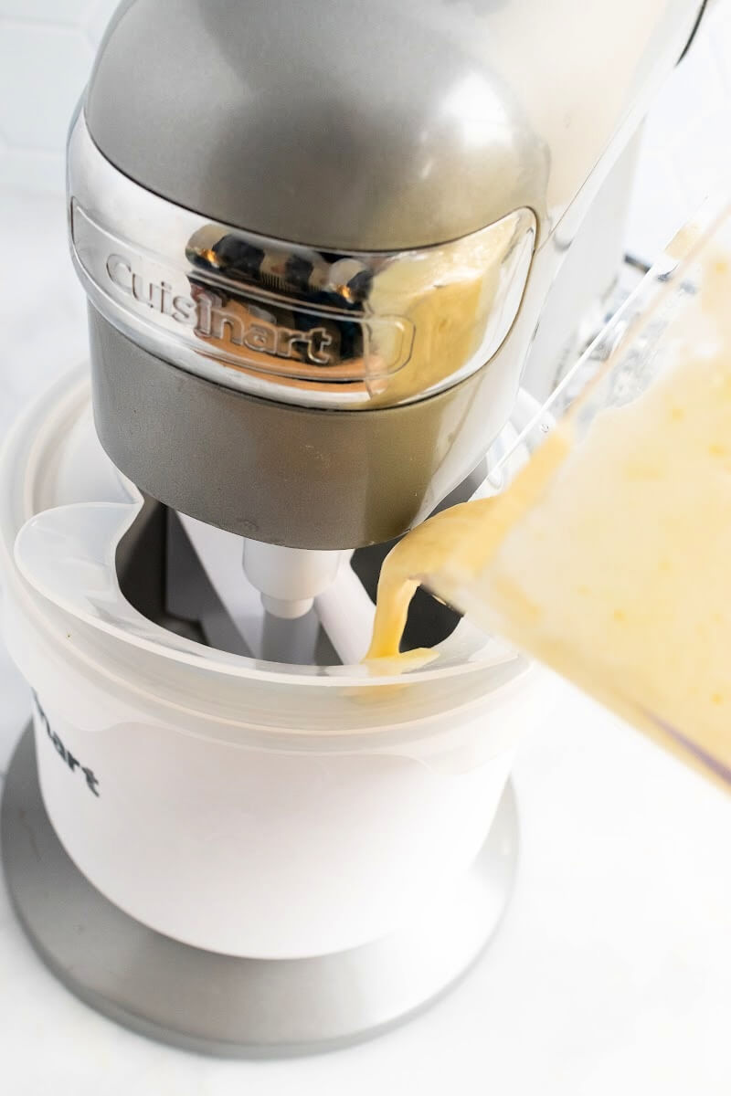 Orange ice cream base being poured into a Cuisinart ice cream machine.